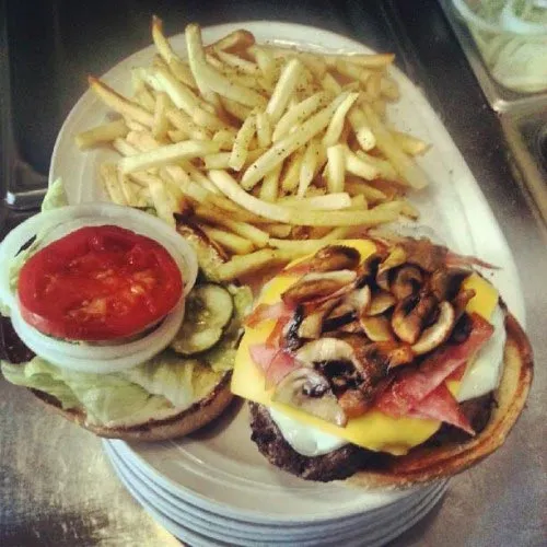 Two burgers, one with mushrooms, and a pile of fries