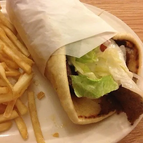 Gyro wrapped in paper with French fries