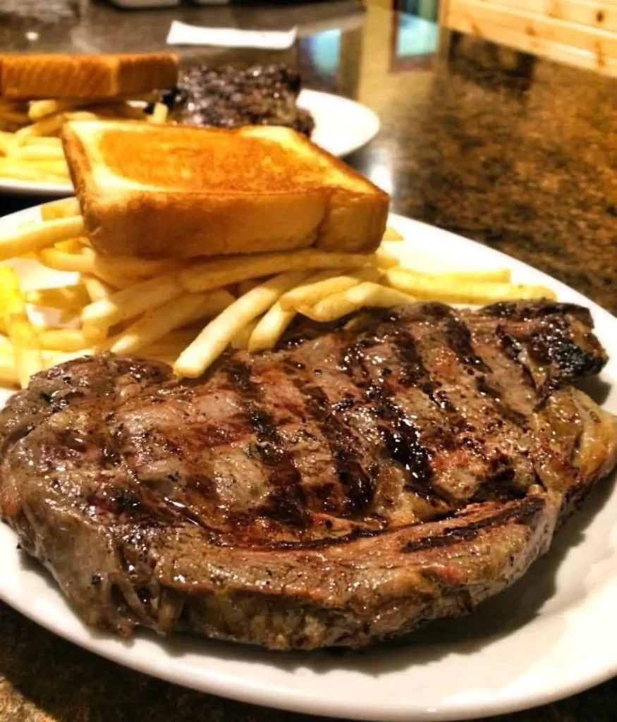 Winn's marinated ribeye filet with grill marks, Texas toast and fries