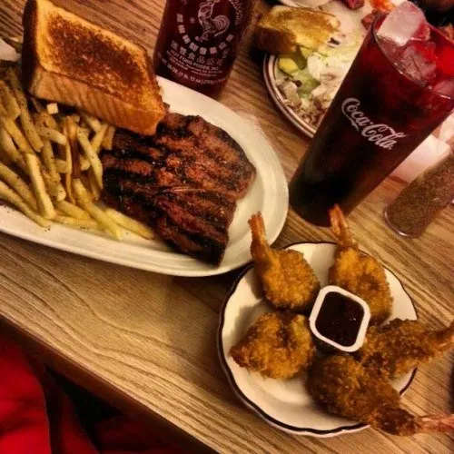 Steak dinner with Texas toast, fries, and fried shrimp